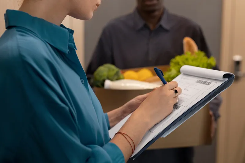 Cliente assinando contrato de fornecimento de refeições na prancheta